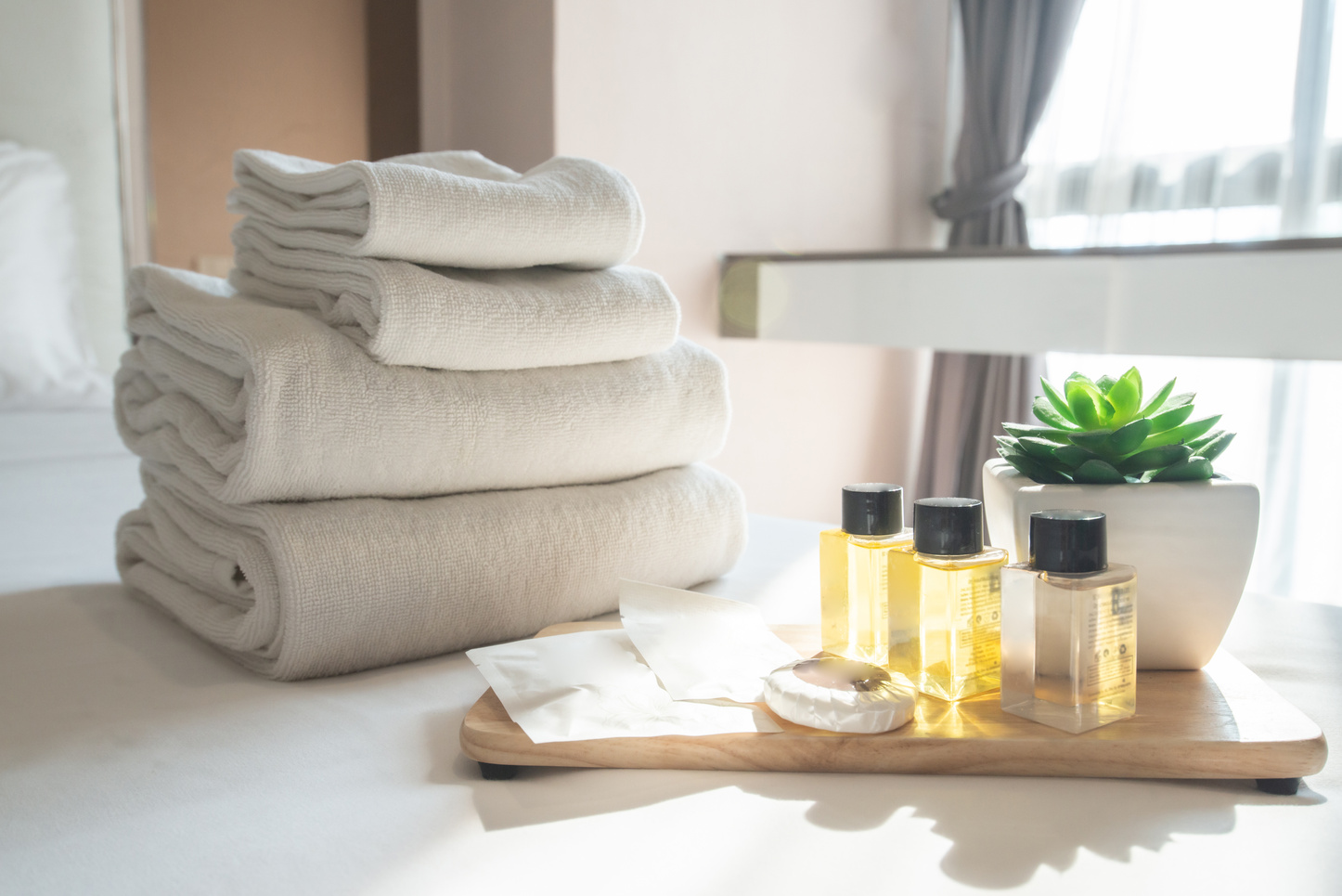 Set of hotel amenities (such as towels, shampoo, soap etc) on the bed.
